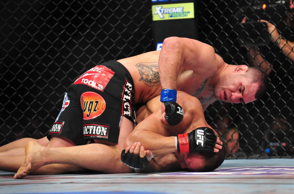 Dec 29, 2012; Las Vegas, NV, USA; Cain Velasquez (top) strikes Junior Dos Santos (bottom) during UFC 155 at the MGM Grand Garden Arena. Mandatory Credit: Gary A. Vasquez-USA TODAY Sports