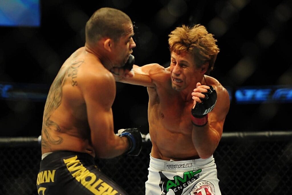 Jul 21, 2012; Calgary, AB, CANADA; Renan Barao (blue golves) and Urijah Faber (red gloves) during the interim bantamweight title bout of UFC 149 at the Scotiabank Saddledome. Mandatory Credit: Anne-Marie Sorvin-USA TODAY Sports