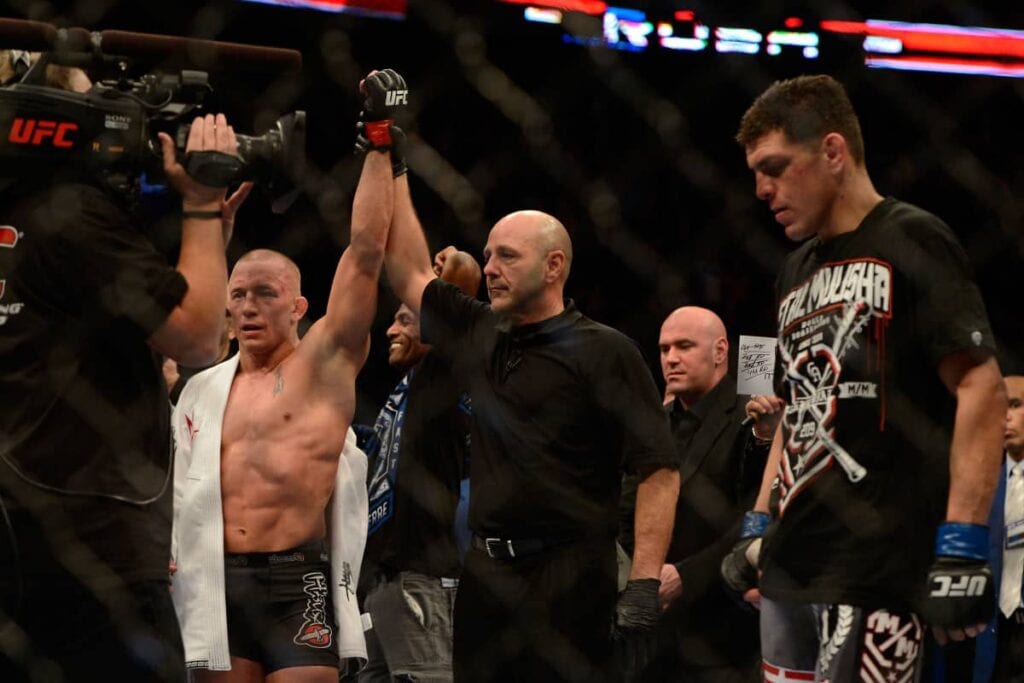 Mar 16, 2013; Montreal, Quebec, CAN; Georges St.Pierre (red) is declared the winner by unanimous decision during the Welterweight title bout against Nick Diaz at UFC 158 at the Bell Centre. Mandatory Credit: Eric Bolte-USA TODAY Sports
