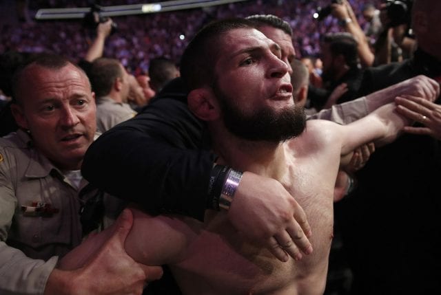 270611985 khabib nurmagomedov is held back outside of the cage after fighting conor mcgregor in a li 1 e1539136600500