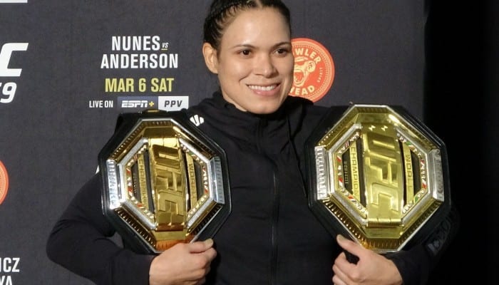 Amanda Nunes poses with her two titles after UFC 259. Photo: Drake Riggs