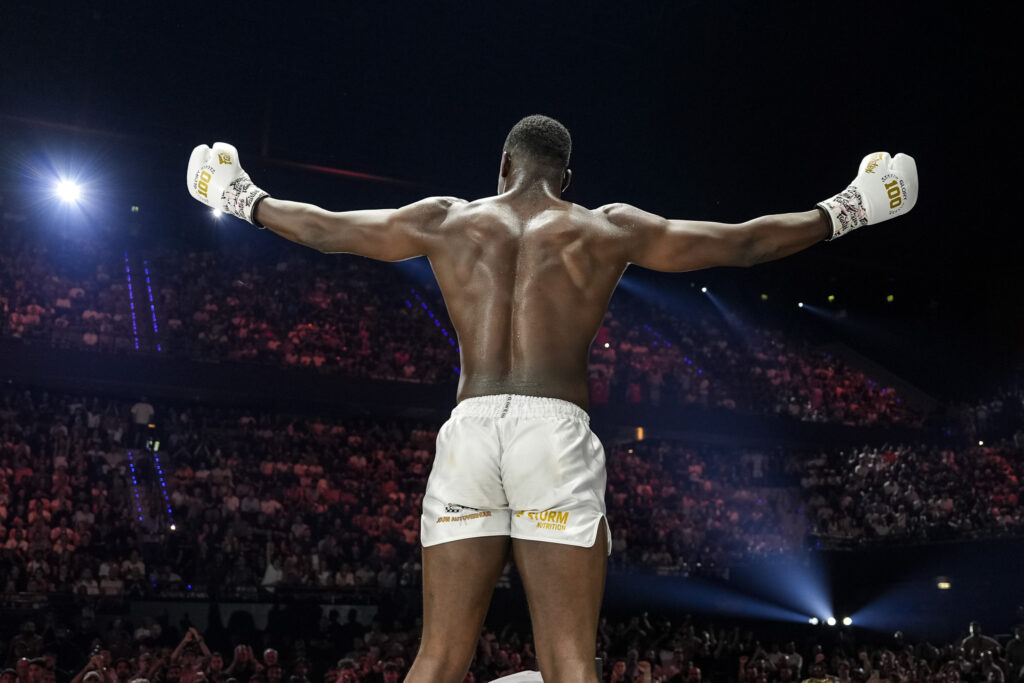Horta, Osaro, Bouzid, and Kromah qualify for the Last heavyweight standing tournament - Glory 100 Results 6 Mory Komah back to camera poses for audience at Glory 100